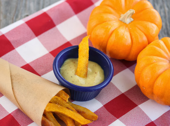 a pumpkin fry being dipped in the dipping sauce