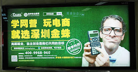 sign with a Caucasian man wearing glasses and holding a scientific calculator