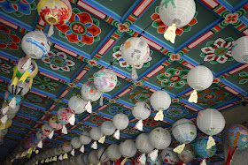 lanterns handing from a colorful ceiling at Bongeunsa Temple in Seoul