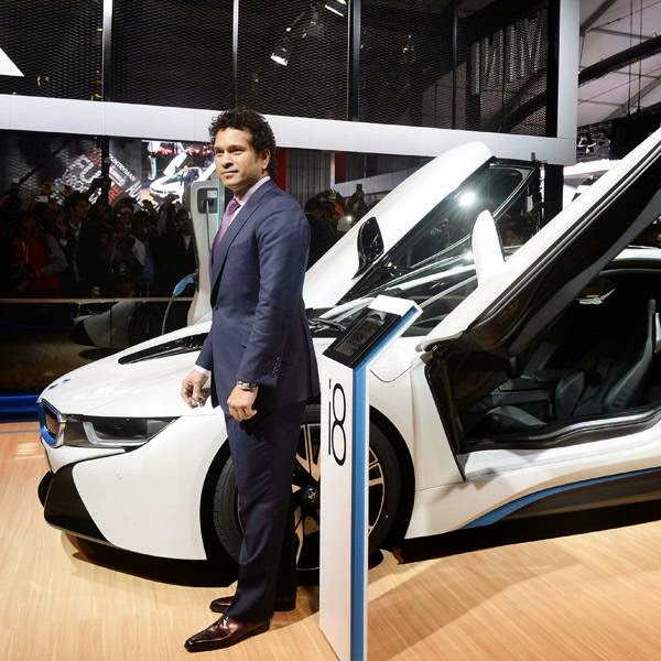 Sachin Tendulkar poses with the BMW i8 Hybrid car at the Auto Expo 2014 in Greater Noida on Wednesday.