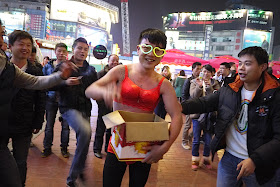 young man wearing red women's underwear and glowing heart glasses in Changsha, China