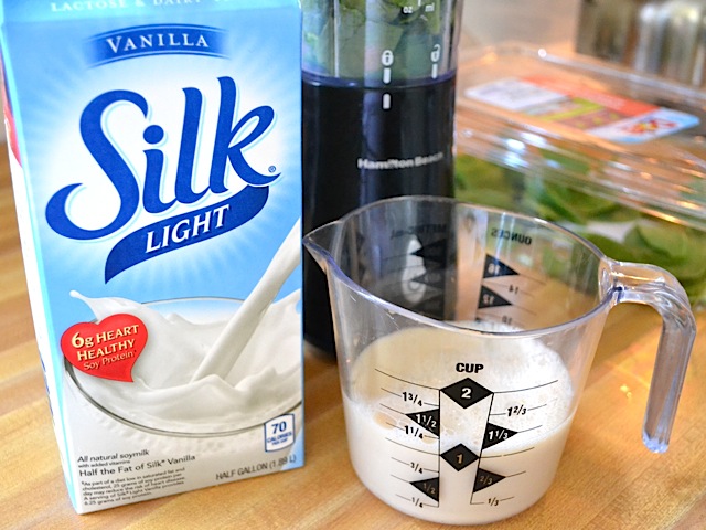 香草丝牛奶倒进量杯，旁边放满牛奶的罐子