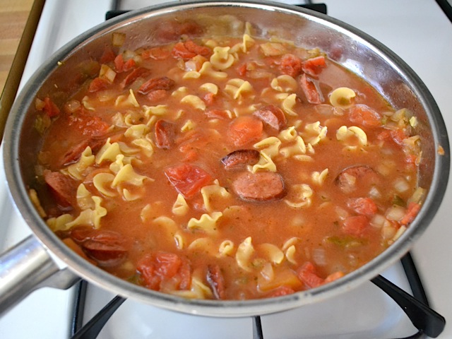 submerged pasta in sauce to cook