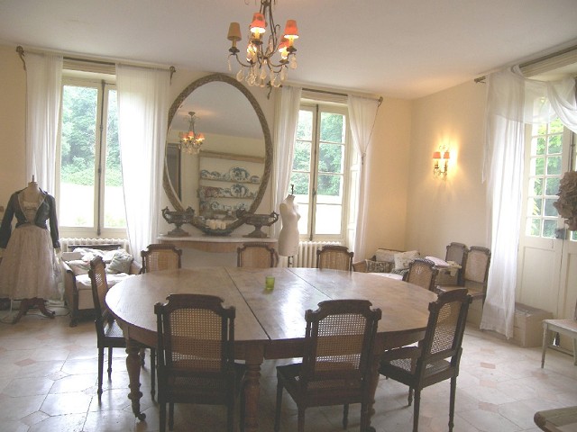 formal dining room with large oval mirror and large windows