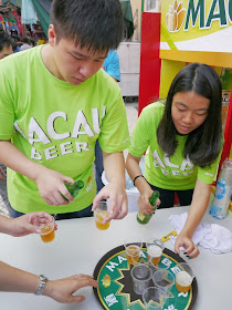 two people pouring samples of Macau Beer