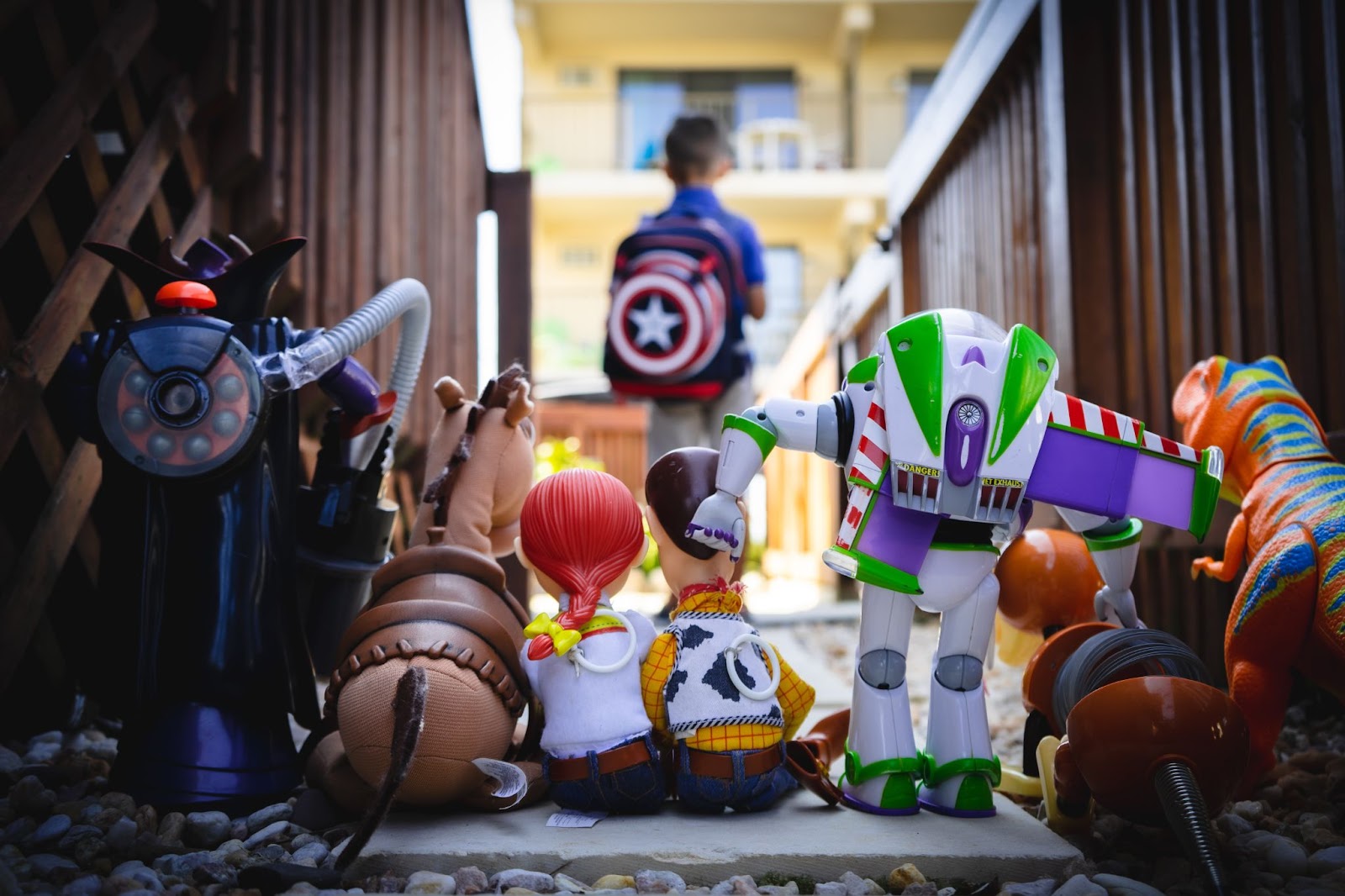 A group of toys lined up with a blurry kid in the background