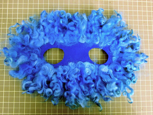 Here is the wig after one time around the base with the wool and the felting tool.