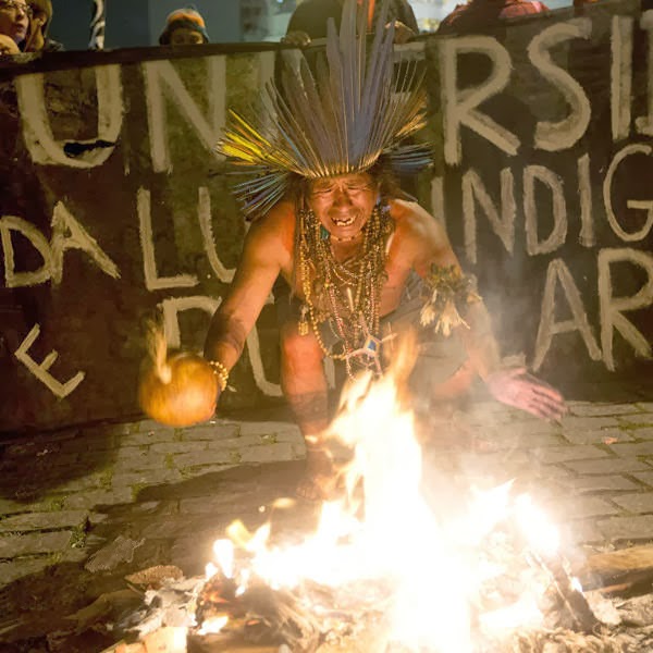 An indigenous man sings in front of a burning barricade in support of teachers on strike during a demonstration in Rio de Janeiro, Brazil
