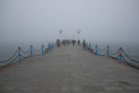 a pier disappearing into the fog