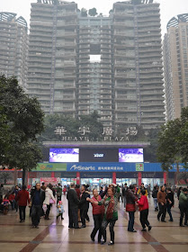 A group of people dance in a large square in Shapingba, Chongqing.