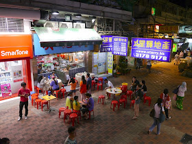 people eating outside on a pedestrian street in Tsuen Wan, Hong Kong