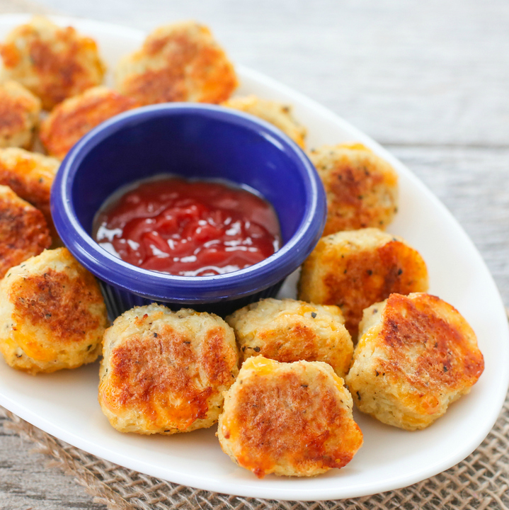 close-up photo of cauliflower tots on a plate with a dipping sauce