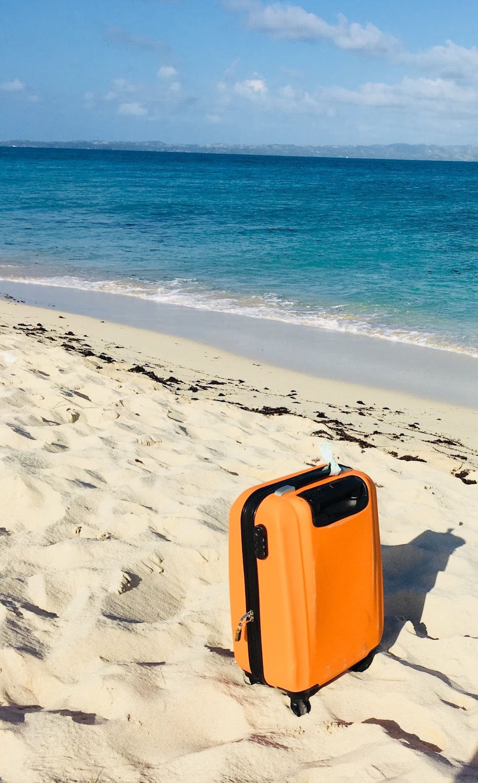 carry on suitcase on beach 