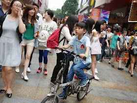 boy riding a bike on a pedestrian street in Dongmen