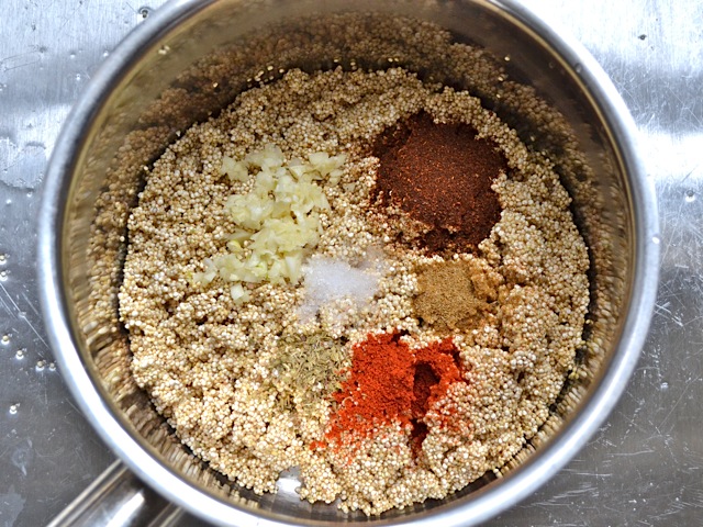 seasonings added to cooked quinoa in pot 