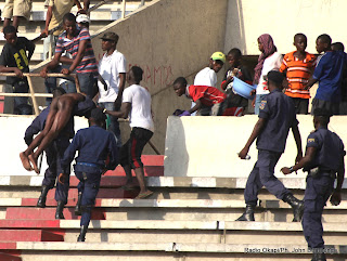 La police assistant un homme battu, déshabillé et fracturé au niveau de la colonne vertébrale par de semeurs de troubles « Kuluna »  le 28/04/2013 au stade des Martyrs à Kinshasa, lors du match DCMP-LUPOPO, score :1-2. Radio Okapi/Ph. John Bompengo
