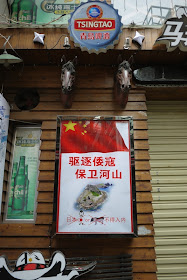 sign forbidding Japanese from entering a bar in Changsha, China, with the words 驱逐倭寇 保卫河山 日本人or猪不得入内