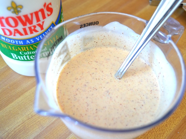 ranch dressing ingredients mixed up in mixing bowl with spoon 