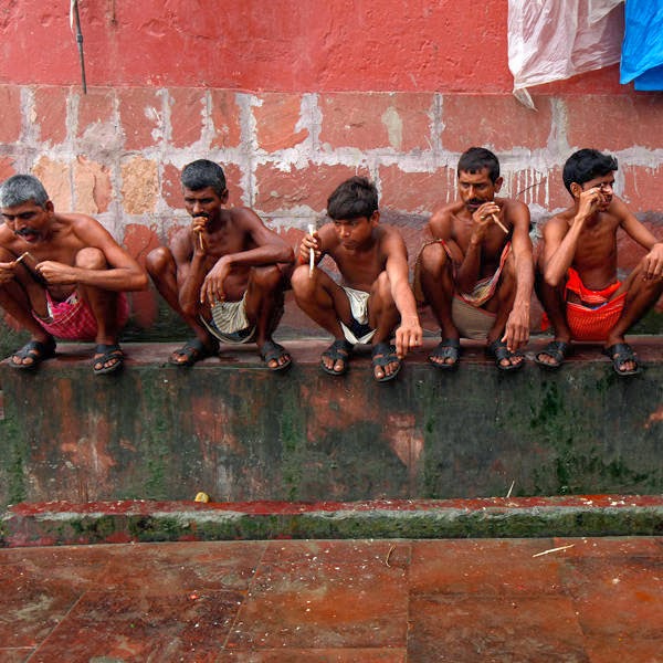 Labourers brush their teeth with neem twigs on the banks of the Ganges river in Kolkata. 
