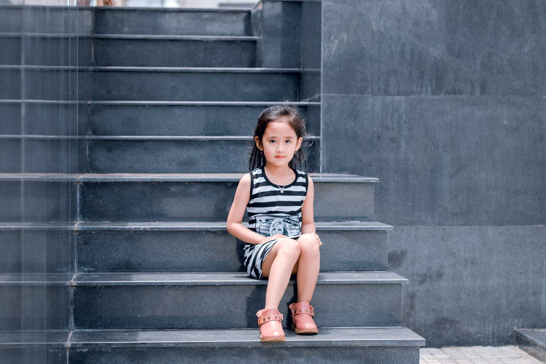 Young girl sitting on some stone steps