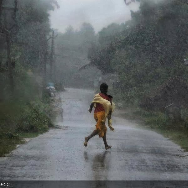 A girl runs for shelter in heavy rain brought by Cyclone Phailin in Ichapuram town in Srikakulam district in the southern Indian state of Andhra Pradesh October 12, 2013.