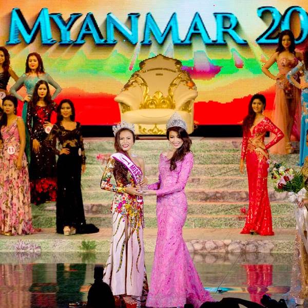 Miss Universe Myanmar 2014 Sharr Htut Eaindra, center left, is crowned by Miss Universe Myanmar 2013 Moe Set Wine, center right, during a pageant in Yangon, Myanmar, Saturday, July 26, 2014.