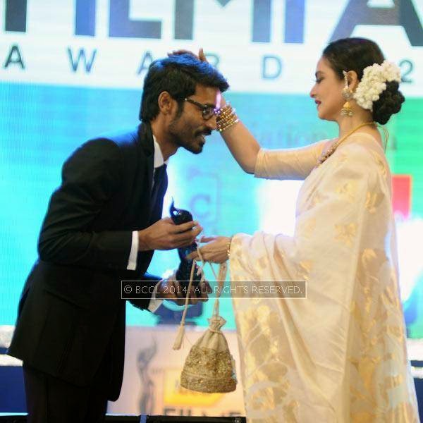 Rekha presents the Critics Best Actor Award to Dhanush for his performance in the Tamil film 'Mariyan' during the 61st Idea Filmfare Awards South, held at Jawaharlal Nehru Stadium in Chennai, on July 12, 2014.