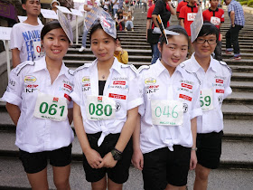 participants in the Macau tray race wearing cutouts of racing scenes on their heads