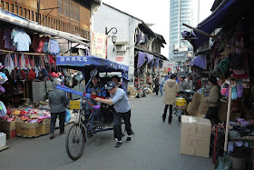 man pushing a bicycle rickshaw at Xiaoshan Street in Shaoxing, China