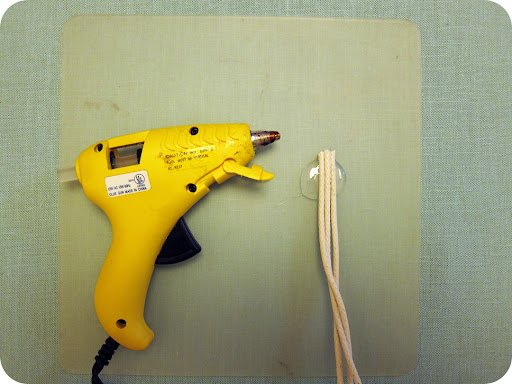 Squirt a dime-size amount of hot glue onto glue pad. Line up ends of thin cotton rope and press into hot glue. Let cool. Squirt a dime-size amount of hot glue onto glue pad. Line up ends of thin cotton rope and press into hot glue. Let cool.