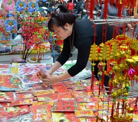 Một người phụ nữ bán bao lì xì và các đồ trang trí trên đường phố Hà Nội. (Ảnh: 
