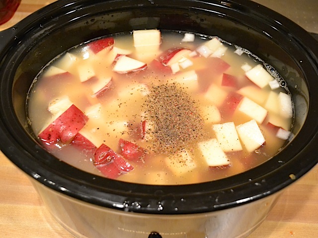 chicken broth and pepper added to slow cooker with vegetables 