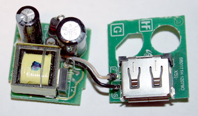 Circuit boards of a Samsung cube USB charger, showing the transformer, switching transistor, filter capacitors, and other large components