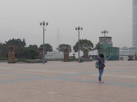 young woman using a selfie stick at Chaotianmen Square
