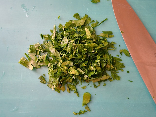 chopped parsley on cutting board with knife 