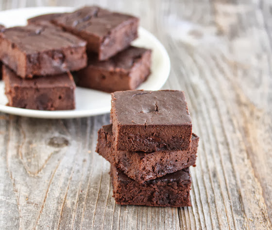 photo of a stack of brownies with a plate of brownies in the background