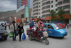 three people on a motorized tricycle cart in Xining, Qinghai, China