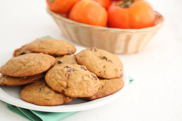 photo of a plate of cookies with persimmons in a basket in the background