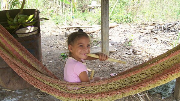 A Nuevo Paraiso girl enjoys some local sugar cane