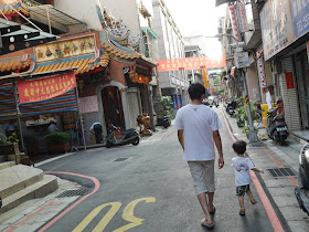 man with boy walking down an alley