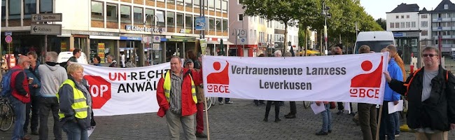 Demonstranten mit Transparenten: »Stopp Un-Rechtsanwälte« und »Vertrauensleute Lanxess Leverkusen IG BCE«.