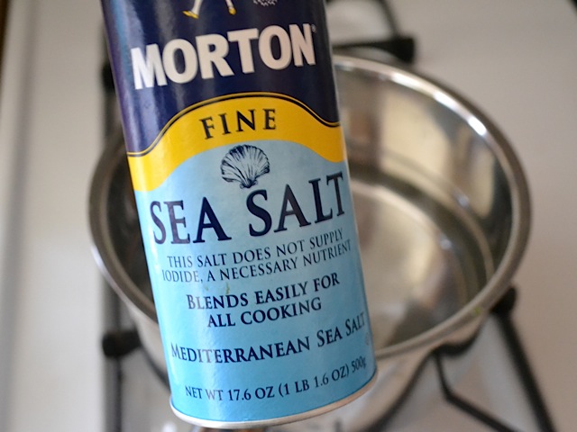 sea salt being added to boiling water 
