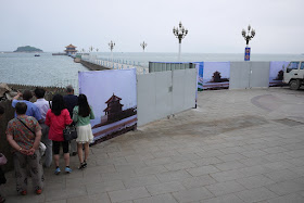 barriers to a pier--some with images of the pavilion at its end