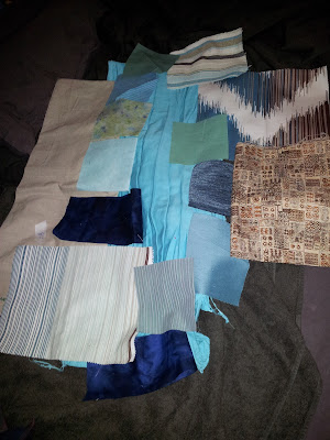 Selection of brown/blue/green fabrics laid out with slightly bad lighting