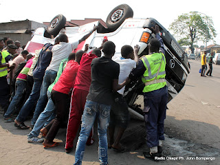 Des policiers et des volontaires tentent de dégager de la voie publique un véhicule accidenté le 9/8/2012 au croisement des avenues Shaba et Kasa-vubu à Kinshasa. Radio Okapi/ Ph. John Bompengo