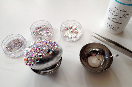 Glue rhinestones to the egg in groups and then let that portion of the egg dry before continuing. This will make the egg easier to handle and ensure that none of your hard work is disrupted.