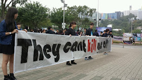 Chinese University of Hong Kong students holding sign reading "They cant kill us all"