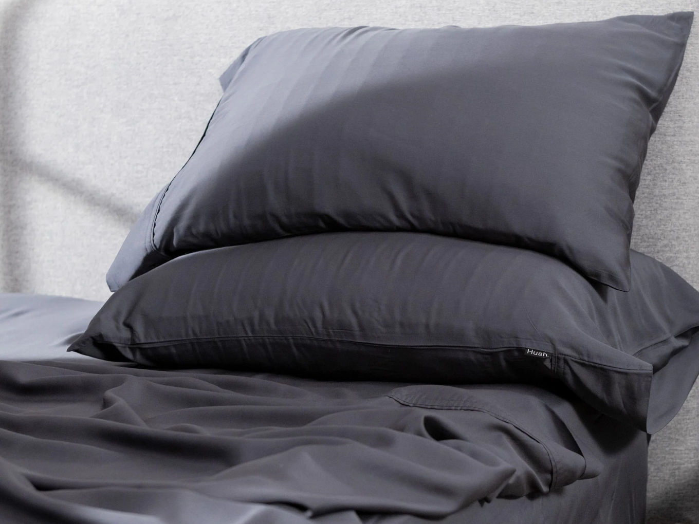 Charcoal gray Hush sheets and pillows on bed