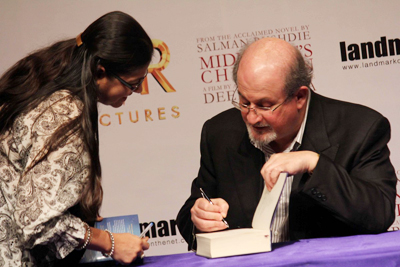 Author Salman Rushdie signs the copy of his novel 'Midnight's Children' during the press meet of the movie based on it, in Mumbai on January 29, 2013. (Pic: Viral Bhayani)