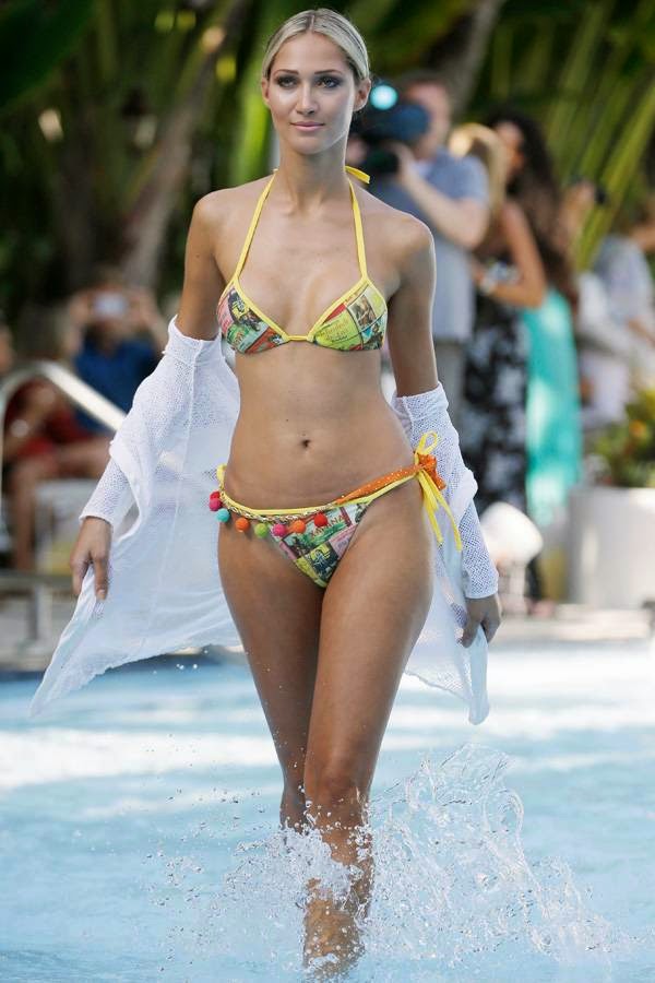 A model walks in a pool wearing swimwear designed by Poko Pano during the Mercedes-Benz Fashion Week Swim show, Friday, July 18, 2014, in Miami Beach, Florida.